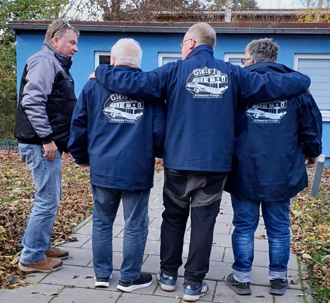 Vereinsmitglieder mit Gleis 19 Jacken im Gespräch