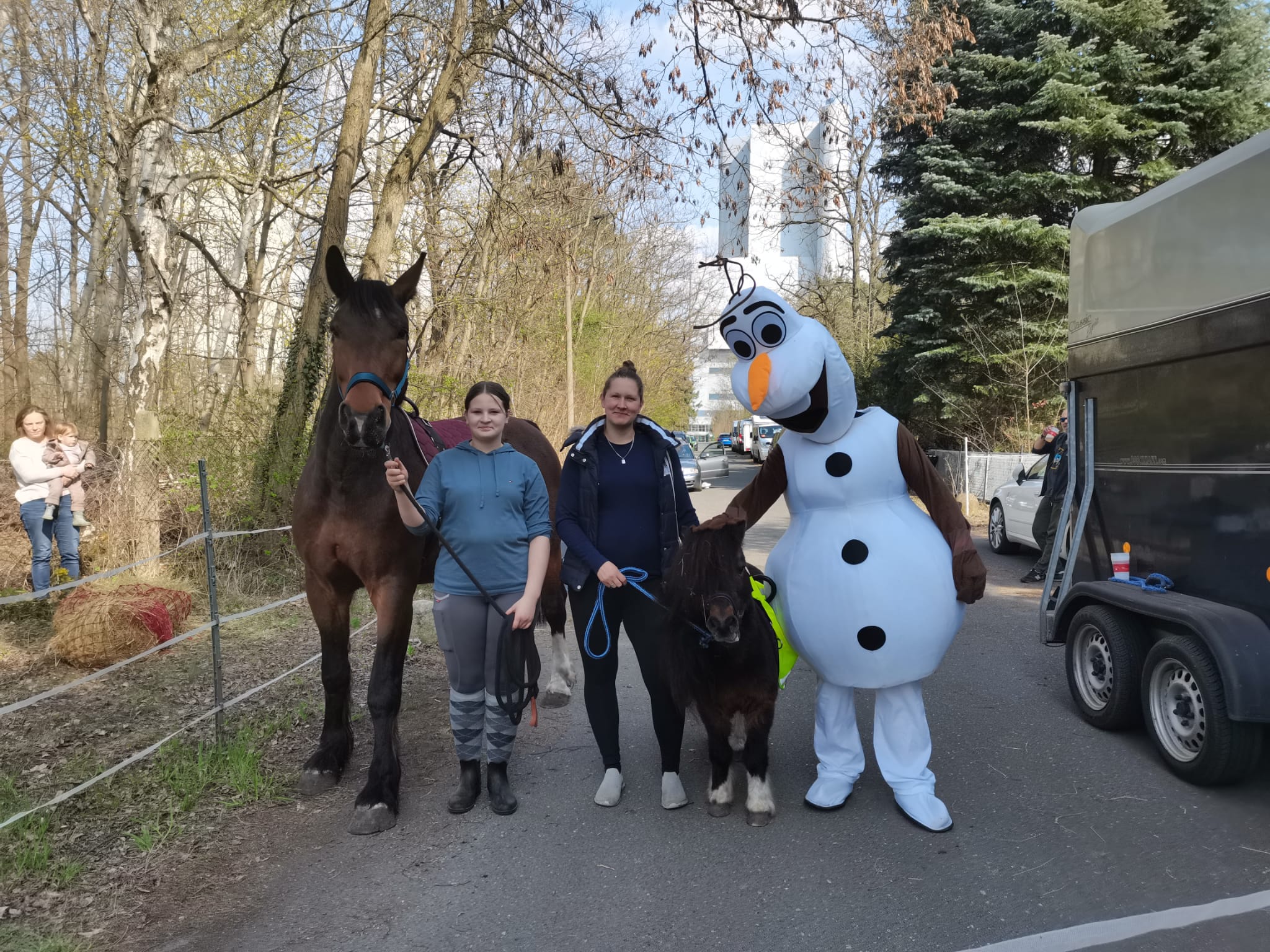 Pferd, Besucher und Schneemannfigur bei einer winterlichen Veranstaltung